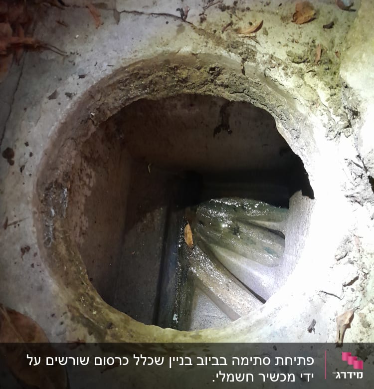 פתח ביוב עם צינור מתכת חלוד ומים